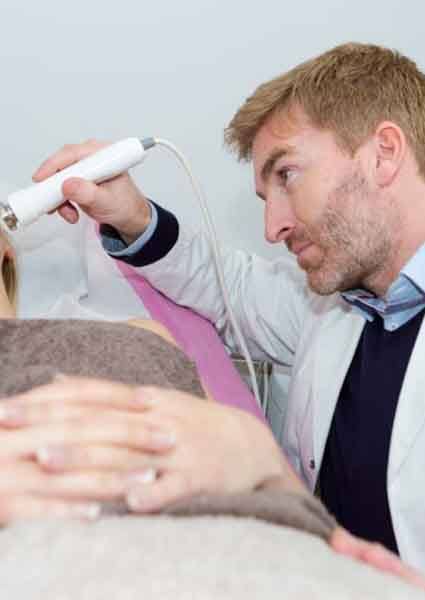 Doctor using ultrasound to diagnose TMJ disorder